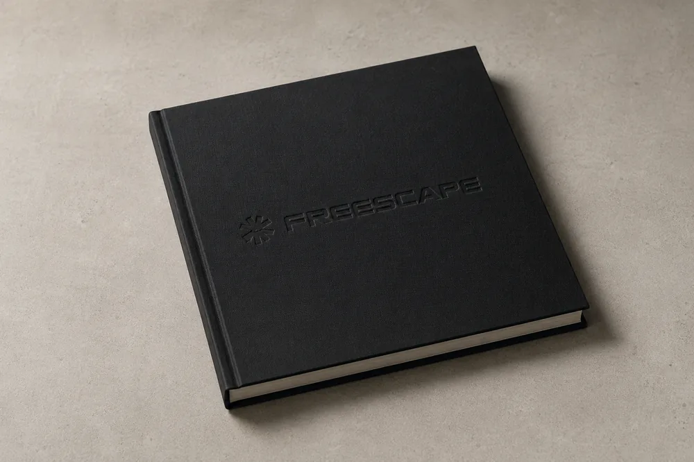 Geschlossenes Lookbook mit Blindprägung des Freescape-Logos auf schwarzem Leinen