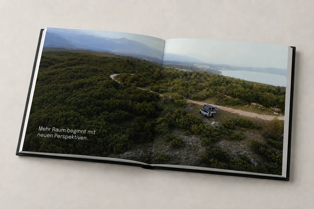 Doppelseite mit Luftaufnahme eines Campervans an einer Küstenstraße